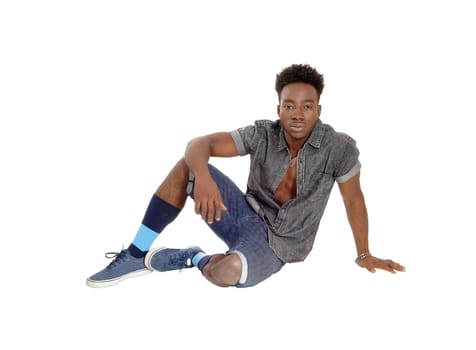 A young African American man sitting on the floor in shorts and sneakers.isolated for white background..