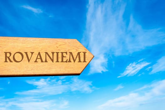 Wooden arrow sign pointing destination ROVANIEMI, FINLAND against clear blue sky with copy space available. Travel destination conceptual image
