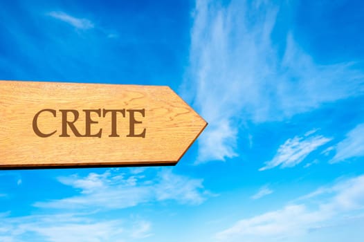 Wooden arrow sign pointing destination CRETE, GREECE against clear blue sky with copy space available. Travel destination conceptual image