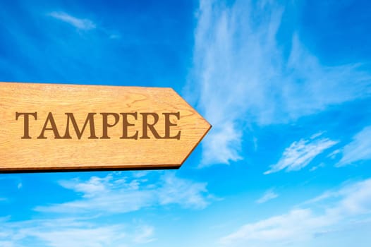 Wooden arrow sign pointing destination TAMPERE, FINLAND against clear blue sky with copy space available. Travel destination conceptual image