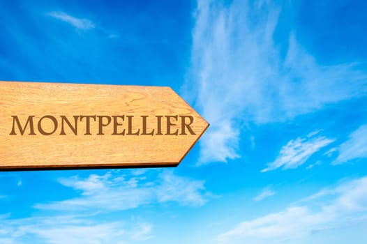 Wooden arrow sign pointing destination MONTPELLIER, FRANCE against clear blue sky with copy space available. Travel destination conceptual image