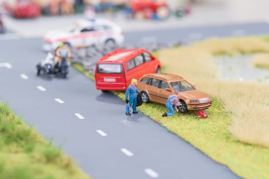 Miniature mechanics replacing a tyre off the roadway