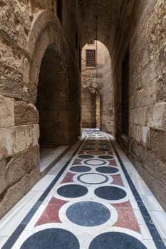 Vaulted passage leading to the Courtyard of Sultan Qalawun mosque with geometrical pattern colorful marble floor, Moez Street, Old Cairo, Egypt