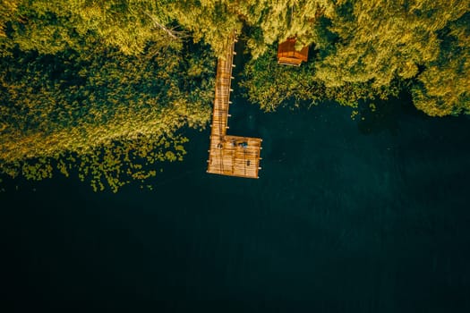 Aerial View Of Fishing Pier With River Lake Around. Top View Of River Coast With Forest In Summer Sunny Day. Drone View. Bird's Eye View