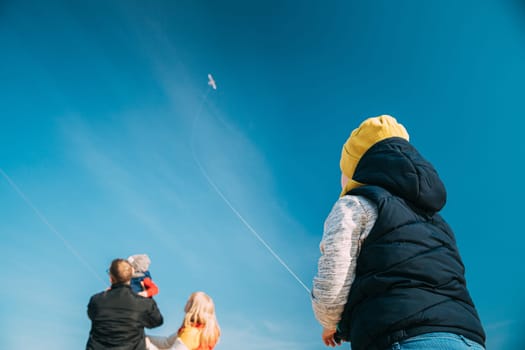 Caucasian Boy Of 6-7 Years Old Takes Up A Twine From A Kite. Pleasant Activity In Fresh Air On A Sunny Spring Or Autumn Day.