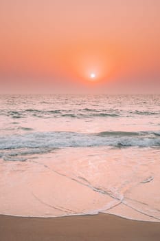 Sunset Sun Shine Above Sea. Natural Sunrise Sky Warm Colors Over Ripple Sea. Ocean Water Foam Splashes Washing Sandy Beach.