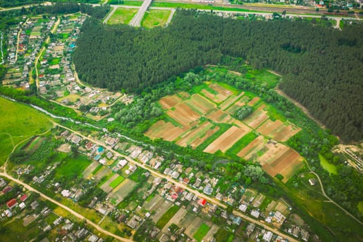 Aerial View Of Vegetable Gardens In Small Town Or Village. Skyline In Summer Evening. Village Garden Beds In Bird's-eye View.