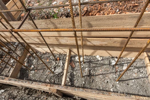 Reinforcement covered with earth during the collapse of the formwork during the installation of strip foundation reinforcement