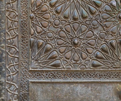 Ornaments of the bronze-plate ornate door of Sultan Barquq mosque, ancient public historic mosque in Old Cairo, Egypt