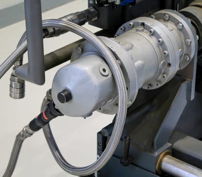 Close-up of a hydraulic motor flanged to a shaft.