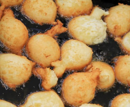 A whole lot of curd balls in a boiling oil bath.