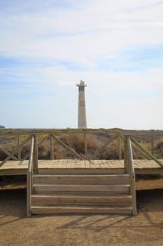 View of a lighthouse standing in the background of the dunes.