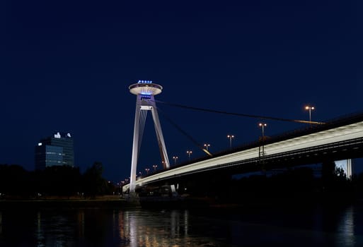 The bridge of the Slovak National Uprising in Bratislava SNP over the Danube River in the evening with a restaurant at a great height