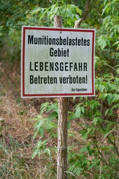 Prohibition sign in a forest in Germany. Translation: ammunition contaminated area, danger to life, no trespassing