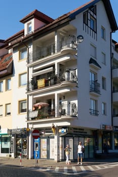Shopping street with small stores and tourists in the center of Kolobrzeg in Poland