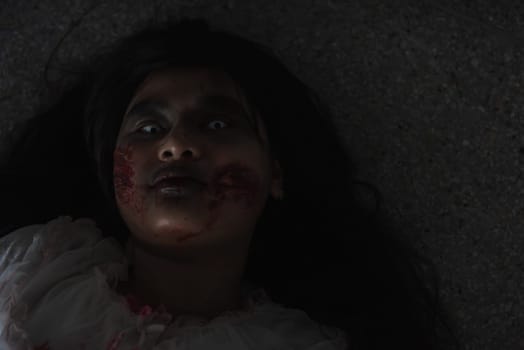 Horror evil woman ghost creepy lying dead in a dark room at house. Female zombie in blood devil is scary she haunted at the abandoned building, Happy Halloween festival day concept