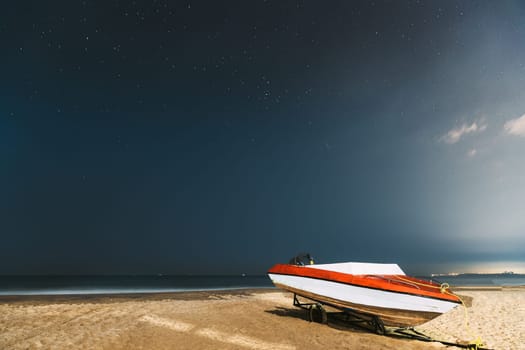 Goa, India. Real Night Sky Stars. Natural Starry Sky Blue Color Above Sea Seascape Ocean Beach. Background. Parked Boat At Coast.