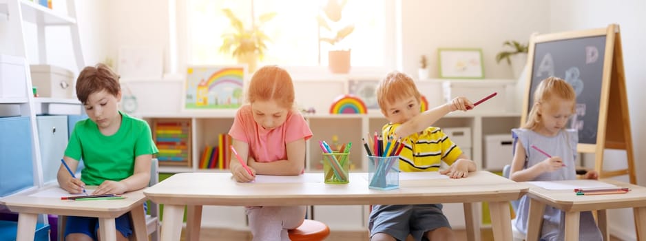 Cute children sitting in the classroom and wring a lesson. Concept of back to school.