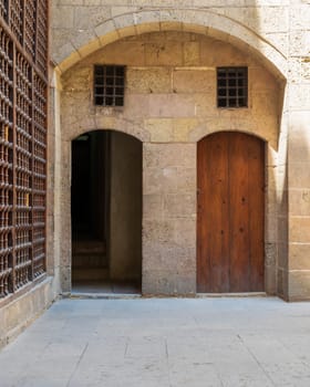 Exterior brick stone passage with two adjacent vaulted opened and closed wooden grunge doors leading to Beit El Sehemy Historical building, Moez Street, Old Cairo, Egypt