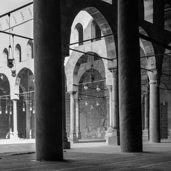 Black and white shot of corridors surrounding the courtyard of public historical Mosque of al Sultan al Nasir Muhammad Ibn Qalawun situated in the Citadel of Cairo, Egypt