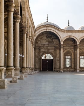Passage surrounding the court of the Great Mosque of Muhammad Ali - Alabaster Mosque - with wrought iron decorated windows and wooden door, alabaster wall, arches and domes, Cairo Citadel, Egypt