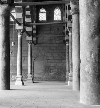 Black and white shot of corridor surrounding the courtyard of public historical Mosque of al Sultan al Nasir Muhammad Ibn Qalawun situated in the Citadel of Cairo, Egypt