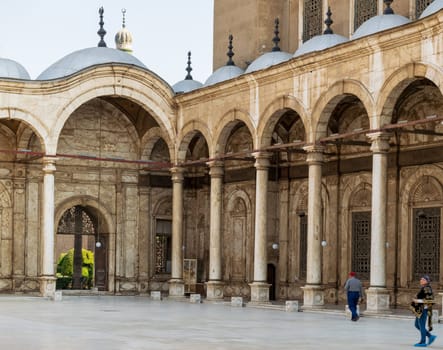 Cairo, Egypt- January 10 2016: Passage surrounding the court of the Great Mosque of Muhammad Ali, Alabaster Mosque, with wrought iron decorated windows, alabaster wall, arches and domes, Cairo Citadel