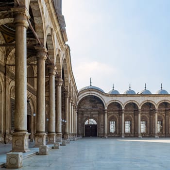 Passage surrounding the court of the Great Mosque of Muhammad Ali - Alabaster Mosque - with wrought iron decorated windows and wooden door, alabaster wall, arches and domes, Cairo Citadel, Egypt