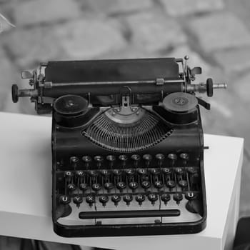 On an outdoor table stands an old nostalgic typewriter.