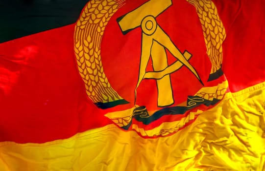 A piece of the flag of the former GDR with emblem, hammer, compass, ear wreath.