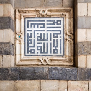 Marble decoration unit with Islamic calligraphy on the exterior stone wall of Sultan al Muayyad Mosque, Old Cairo, Egypt. Text translates: In The Name of Allah, the Beneficent, the Merciful