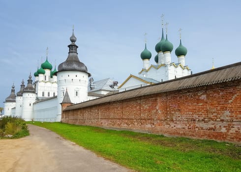 Rostov Veliky, Russia - September 13, 2021: Brick wall of the Rostov Kremlin with a view of the Tower of St. Gregory and the tops of the churches. Golden Ring of Russia.