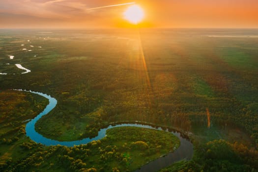 Belarus. Aerial View. Beautiful Sunset Sun Sunshine Above Summer Green Forest And River Landscape In Sunny Evening. Top View Of European Nature From High Attitude In Summer Sunrise. Bird's Eye View.
