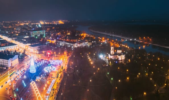 Gomel, Belarus. Main Christmas Tree And Festive Illumination On Square In Homel. New Year In Belarus. Aerial Night View. Peter And Paul Cathedral In Rumyantsevs And Paskeviches Park. Local Landmark.