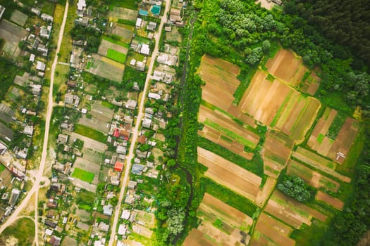 Aerial View Of Vegetable Gardens In Small Town Or Village. Skyline In Summer Evening. Village Garden Beds In Bird's-eye View.