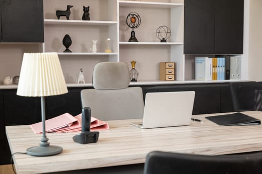 Comfortable office chair near wooden table with laptop computer, Interior of an office desk workspace room, empty no body