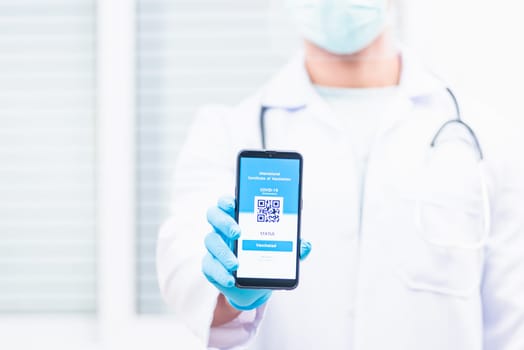 Doctor man in medical mask show app smartphone mobile digital vaccinated passport coronavirus (COVID-19) certificate to confirm, vaccine health pass concept