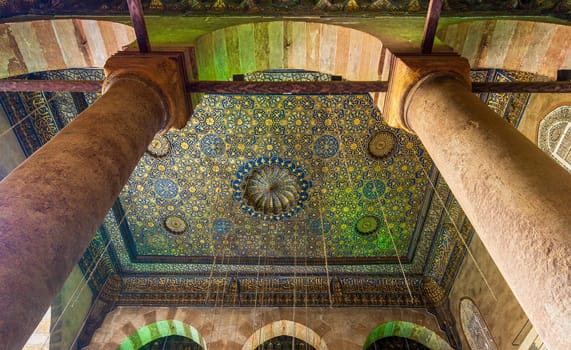 Ornate ceiling with blue and golden floral pattern decorations framed by two columns at Sultan Barquq mosque, Al Moez Street, Old Cairo, Egypt
