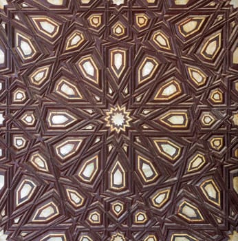 Closeup of wooden arabesque decorations tongue and groove assembled, inlaid with ivory and ebony, on old aged door, Rosetta City, Egypt
