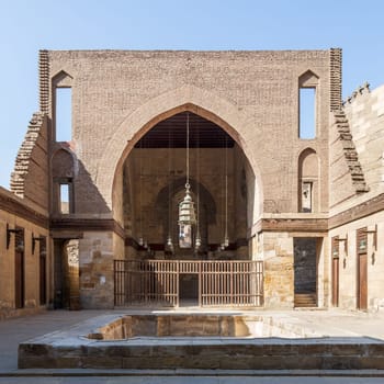 Main courtyard of public historic mosque of Sultan Al Nassir Qalawun with huge arch, Cairo, Egypt