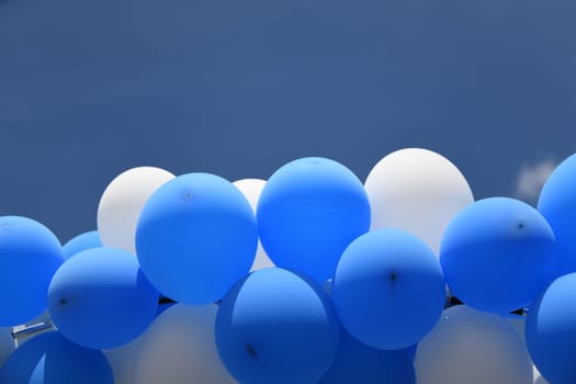 Blue,white balloons as decoration against a blue sky at a celebration,festival or party in summer.