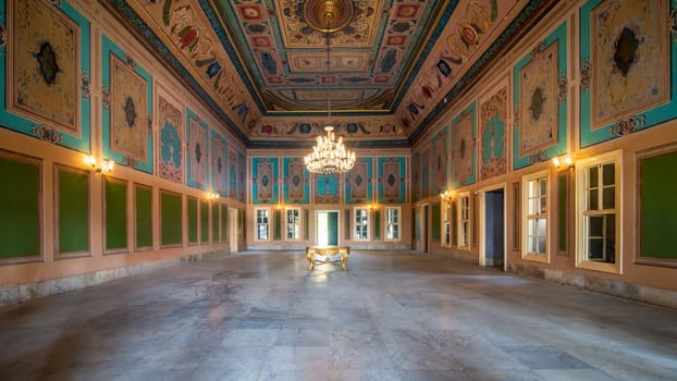 Royal era historic Manasterly Palace with beautiful elegant carved frames on green wall with ornate borders, floral decorated ceiling, chandelier, narrow windows, and marble floor, Cairo, Egypt