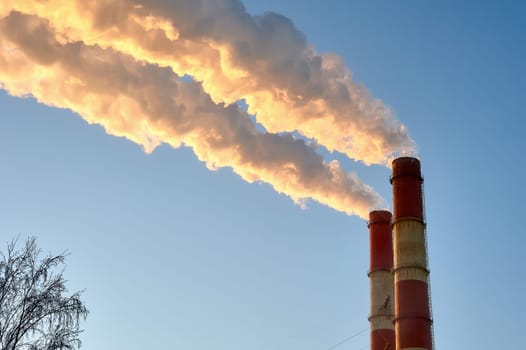 white smoke is coming out of the pipes in the blue sky. High quality photo