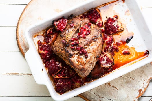 Piece of meat fried with pomegranate in baking dish