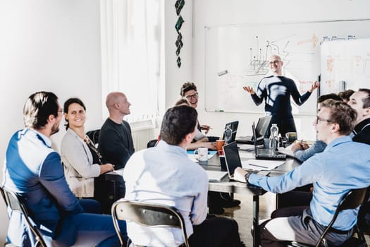Relaxed informal IT business startup company meeting. Team leader discussing and brainstorming new approaches and ideas with colleagues. Startup business and entrepreneurship concept.