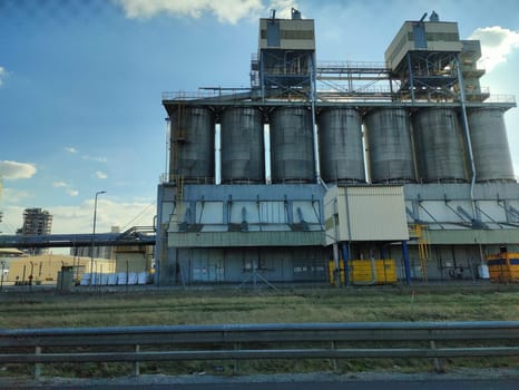 Oil storage tank terminal and tanker, petrol industrial zone shot from a moving car.
