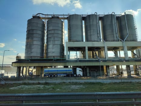 Oil storage tank terminal and tanker, petrol industrial zone shot from a moving car.