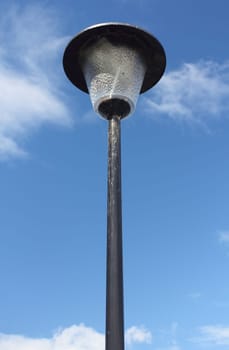 A street lamp, with blue sky in the background.Eine Straßenlaterne, mit blauem Himmel im Hintergrund.