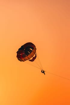 Parasailers Flying On Colorful Parachute In Sunset Sunrise Sky. Active Hobby.