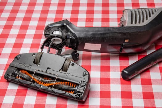 Repair of household appliances. Professional technician repairs a vacuum cleaner. Household appliances customer service. Battery hoover. Repair by a specialist on site.